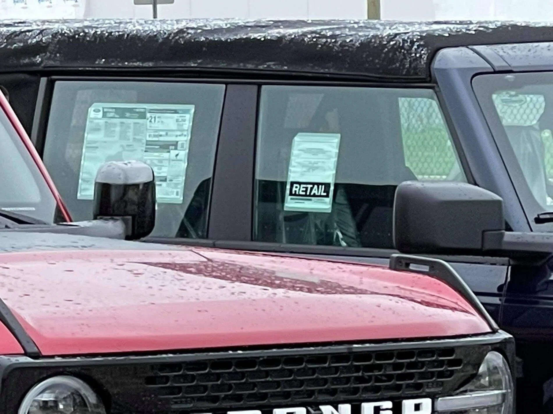 Ford Bronco Wildtrak vs Base Bronco 4-Door Side-by-Side Shows Height and Equipment Difference 2021 Bronco -- Rapid Red Wildtrak + Shadow Black Base 4-Doors 4