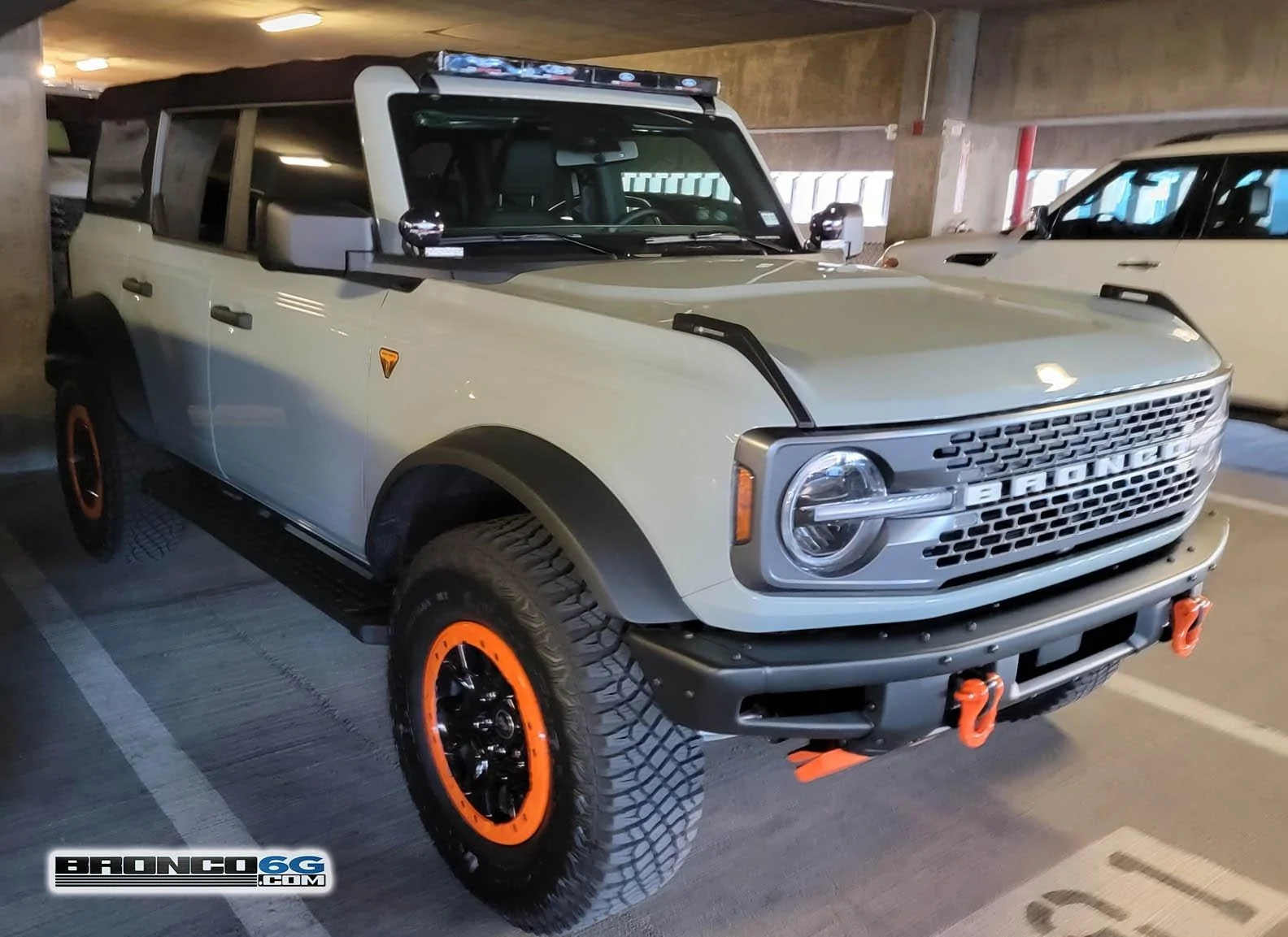 Ford Bronco CACTUS GRAY Bronco Club Cactus Gray Bronco Badlands Sasquatch 4-Door with orange tow hooks, orange beadlock rings, ro