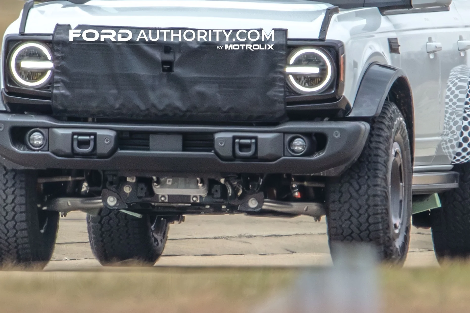 Ford Bronco "Stock" (Prototype?) Bronco Takes on NORRA Mexican 1000 and shows suspension & body changes Ford-Bronco-Four-Door-Prototype-Spy-Shots-New-Variant-March-2026-Exterior-003-front-fascia-DR