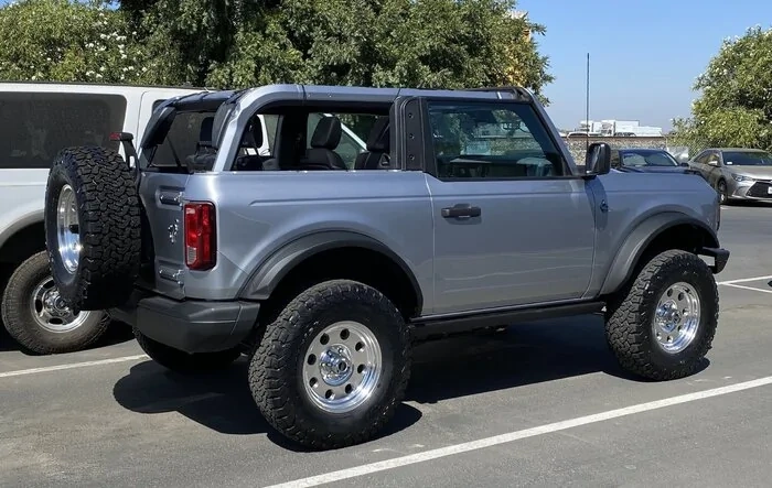 Flicka, the 2 Door Iconic Silver Bronco on polished revolver mags wheels