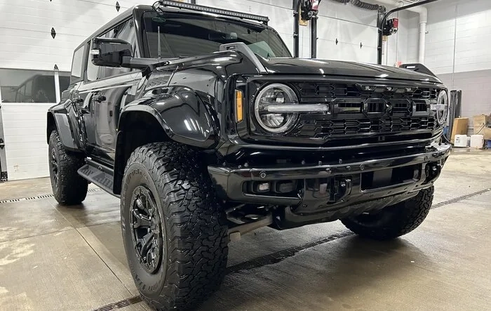 Black Bronco Raptor with painted flares, grille, bumpers + light bar